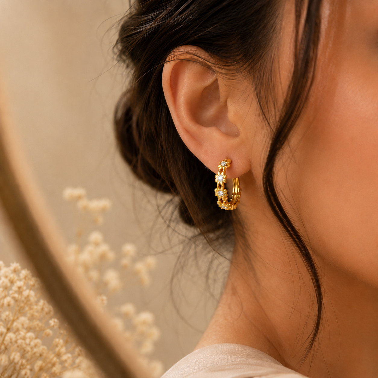 Woman wearing Élodie Bloom Huggie Earrings showcasing elegant floral sparkle